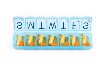 Daily portion of vitamins, drug medicines, tablets, dietary supplements in pill organizer or plactic pill box. A weekly container of tablets, vitamins. Nutritional supplements