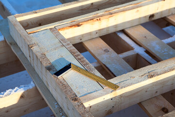 Steel square tool is on timber logs, construction site