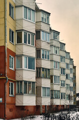 Part of the facade of a multi-storey building, many glazed balconies create an interesting picture, a winter cityscape