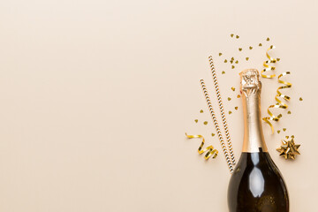 bottle of champagne with glasses and colorful confetti on colored background. top view flay lay