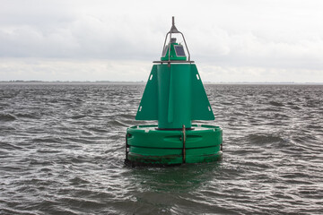 A green channel marker buoy in the water.