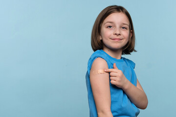 Vaccinated Female Child Showing Arm With Adhesive Bandage After Vaccine Injection On Light Blue...