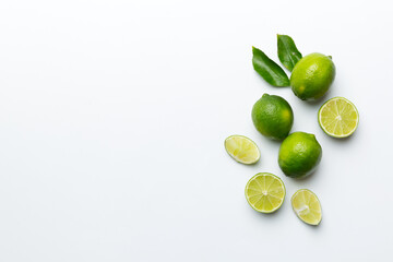 Lime fruits with green leaf and cut in half slice isolated on white background. Top view. Flat lay with copy space
