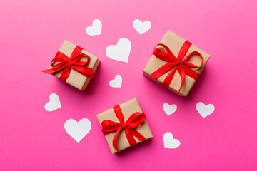 Valentine day composition Background: red gift box with bow and heart. Christmas present. View from above. Holday greeting card