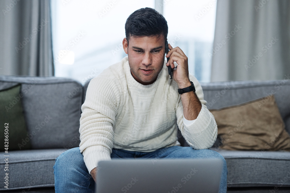 Poster Press on and keep it productive. Shot of a young man using a laptop and smartphone while working from home.