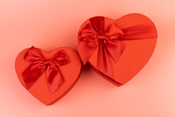 Red box in shape of heart. Gift box for Valentine's Day. Isolated on pink background.