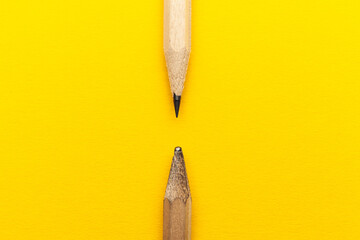 Scribbled and new pencil on a yellow background. Experienced and inexperienced.