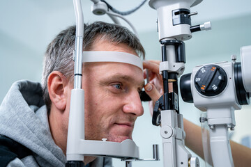 Ophthalmologist and patient testing eyesight. Man doing eye test with optometrist. Ophthalmologist...