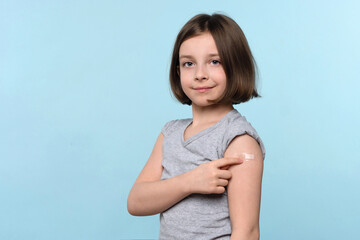 Child Shows Band Aid After Vaccination. Preteen Girl After Getting Vaccine. Vaccination and Protection Against Covid 19. Population Antiviral Immunization. Children Covid-19 Prevention. Health Care - obrazy, fototapety, plakaty