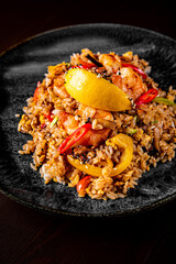 Fried rice with shrimp and vegetables in plate on wooden table background