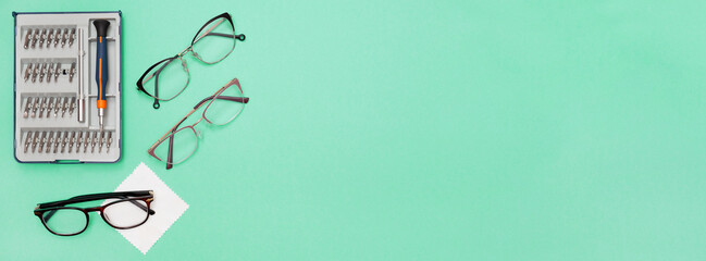 Banner. Glasses repair concept. On a blue background, a group of glasses and a screwdriver. Eyewear...