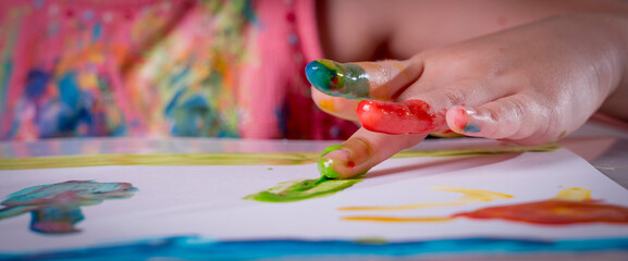Child girl enjoying her painting. Horizontal image.