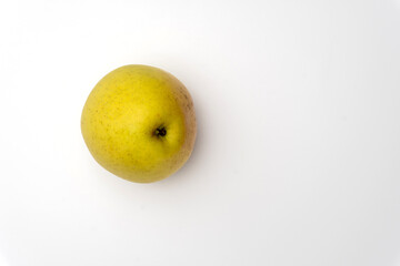 An isolated golden delicious apple with water beads on white background