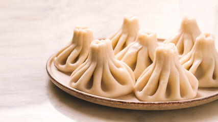 Traditional Georgian dish, Khinkali Kalakuri, on a marble table, selective focus, rustic, toned photo, horizontal, no people,