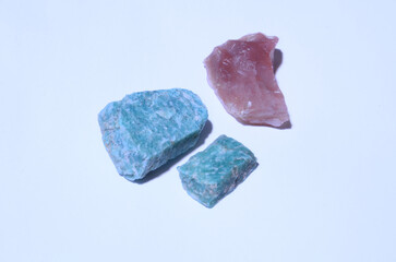 Two green stones and one burgundy on a blue background.