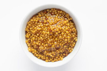 Grainy mustard. Top view. Whole grain mustard. French mustard in white bowl isolated. 