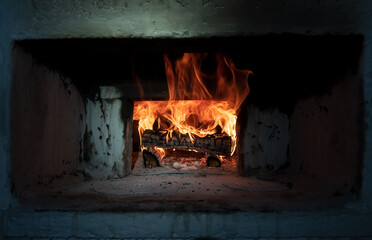 Retro Russian stove in which firewood burns in a village house. Kindling the oven for cooking. Traditional cuisine. 