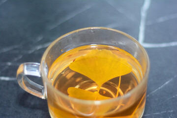Ginkgo biloba tea. A hot drink, tea with Ginkgo biloba leaves in a glass cup.