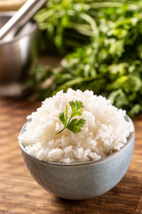 Cooked rice in a bowl with fresh parsley