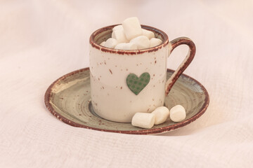 Green mug with a heart, cocoa, coffee with marshmallows on white background. Drinking coffee with love. Copy space, mock up