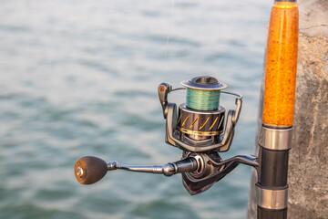 The crank of a fishing rod with reel foot, reel seat, spool, coiled line and spool brake