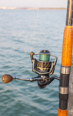 The crank of a fishing rod with reel foot, reel seat, spool, coiled line and spool brake