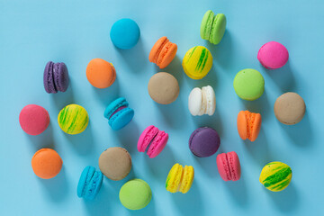 Cake macaron or macaroon on turquoise background from above, colorful almond cookies, pastel...