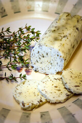 Closeup of homemade herb butter, made with English thyme (Thymus vulgaris), on a decorative plate