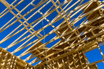 Fragment of a new home under construction wood framing beams