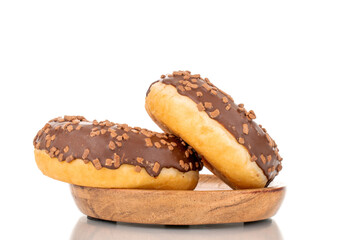Two sweet chocolate donuts on a wooden saucer , macro, isolated on white.