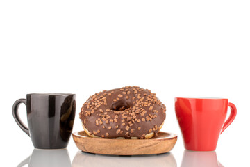 One sweet chocolate donut on a wooden saucer with red and black cups , macro, isolated on white.