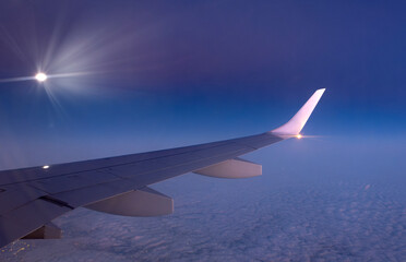 Aircraft wing in flight seen from inside. above the clouds.