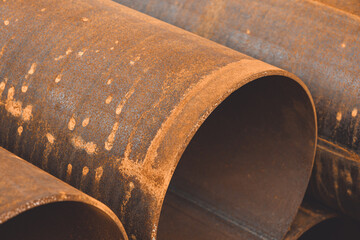 Stack of big rusty steel pipe at a construction site. Installation of pipeline. Metal water tubes....