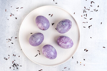 Coloring Easter eggs with natural dye carcade tea from hibiscus flowers. Trendy very peri colour with marble effect. Top view.