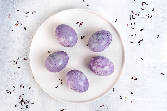 Coloring Easter eggs with natural dye carcade tea from hibiscus flowers. Trendy very peri colour with marble effect. Top view.