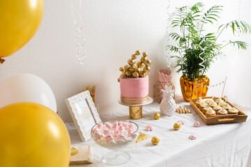 Holiday birthday table with cake and ballons. Pink and golden decoration