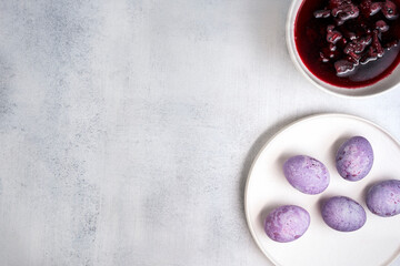 Coloring Easter eggs with natural dye carcade tea from hibiscus flowers. Trendy very peri colour with marble effect. Top view.