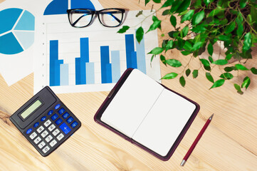 office workstation with computer, graphs, calculator and glasses. Top view. High quality photo