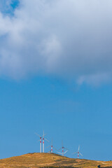 Fototapeta na wymiar Windräder auf einem Hügel einer Mittelmeerinsel