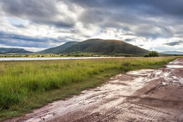 Landscape view of a lake surrounded by mountains and green savanna grassland, Pilanesburg Nature Reserve, North West Province, South Africa