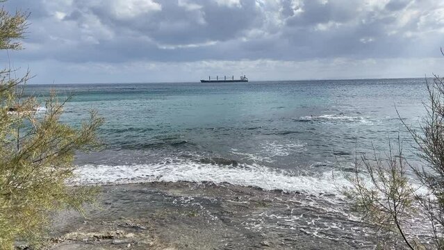 Ship In The Distance . Movie. No Audio. Cargo vessel off the shore of Syros island in Greece. 