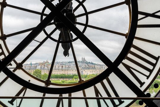 View of church Sacre Coeur in Montmartre through a large Clock from Museum d'Orsay in Paris