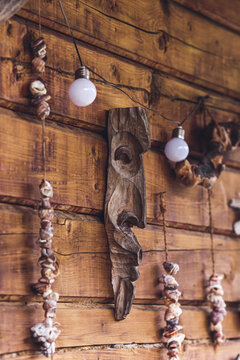 Amulets on rope hang on wooden wall of house