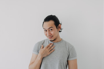 Funny cute shy Asian man in grey t-shirt on isolated white background.