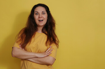 Obraz premium Joyful and surprised woman in a yellow tank top with long dark hair.