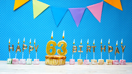 Happy birthday from the letters of the candles number 63 on a blue background with polka dots white...