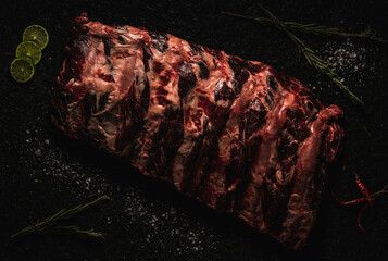 corte de res  COSTILLA RIB EYE  sobre laja de piedra  con decoración como sal, pimienta limón,...