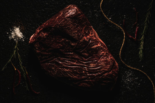 corte de res  VACIO   sobre laja de piedra  con decoraci&oacute;n como sal, pimienta lim&oacute;n, chile de &aacute;rbol  , romero y un cuchillo  