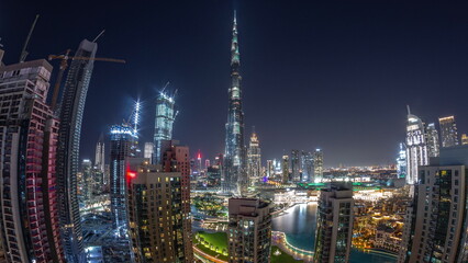 Panorama of Dubai Downtown cityscape with tallest skyscrapers around aerial all night timelapse.