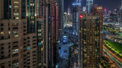 Aerial cityscape night timelapse with illuminated architecture of Dubai downtown.